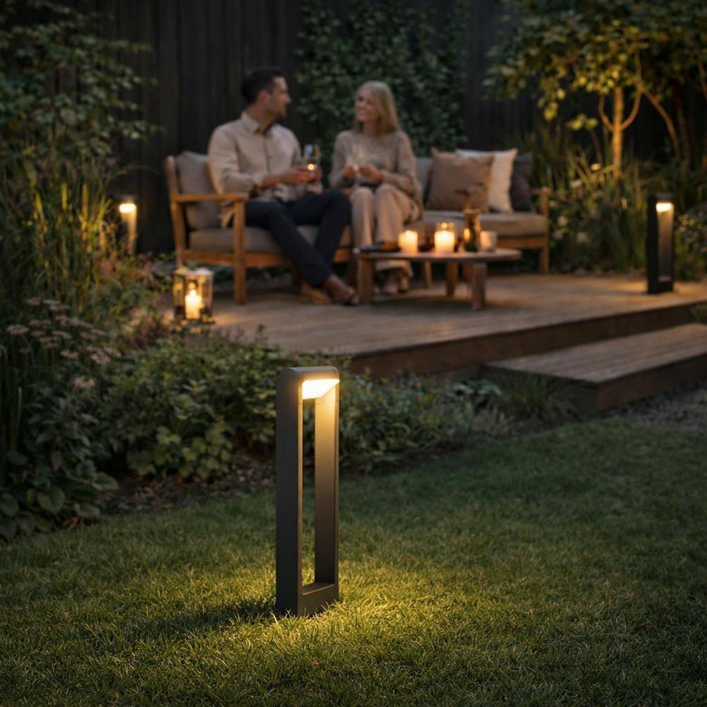 Graue Gartenlampe beleuchtet Steinweg bei Nacht.