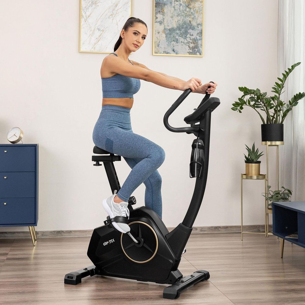Frau auf Heimtrainer in blauer Sportkleidung. Heimtraining. Heimtrainer für Zuhause