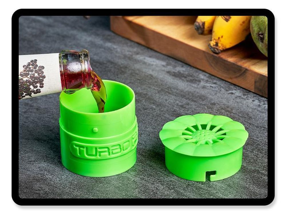 Grüne TURBO Fruchtfliegenfalle wird mit Essig befüllt, daneben der geöffnete Deckel