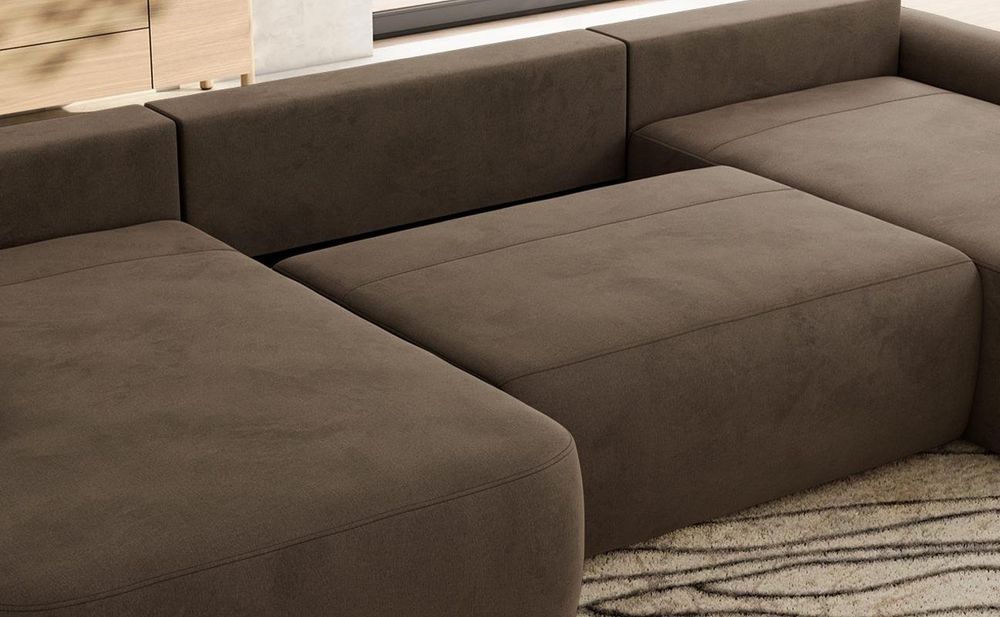 Detailansicht eines grauen Sofas mit Bettkasten und gepolsterter Sitzfläche.