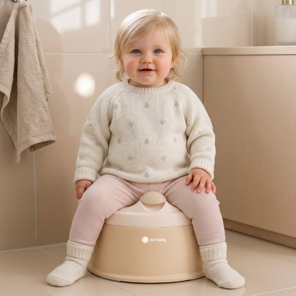 Dieťa sedí na béžovom nočníku SUN BABY NESTPOT v kúpeľni.