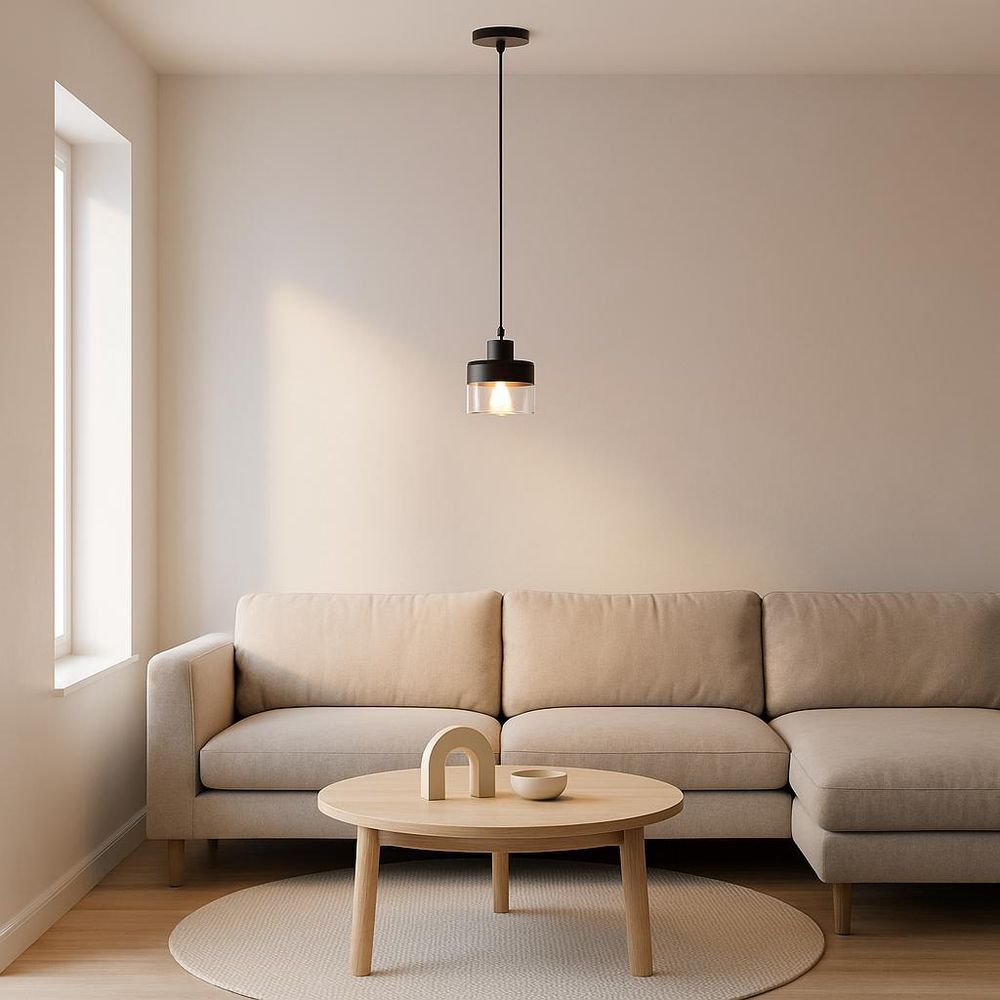 Pendelleuchte, die ein beigefarbenes Sofa und einen runden Couchtisch aus Holz beleuchtet.