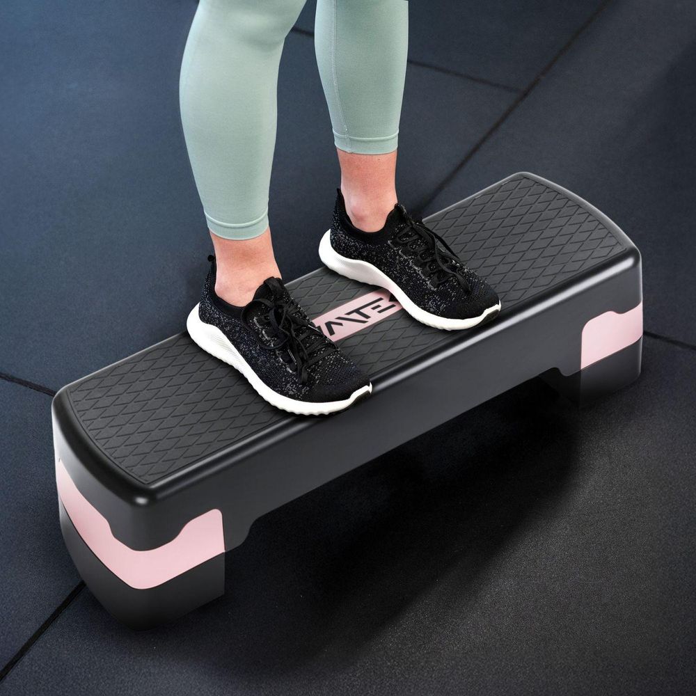 Füße in Sportschuhen auf dem Stepper.
