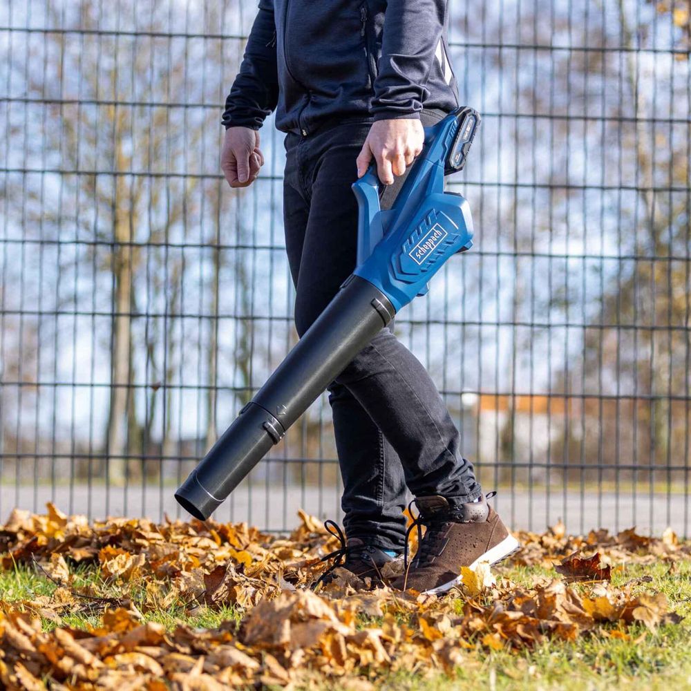 Das Bild zeigt eine Person beim Arbeiten mit dem Laubbläser.