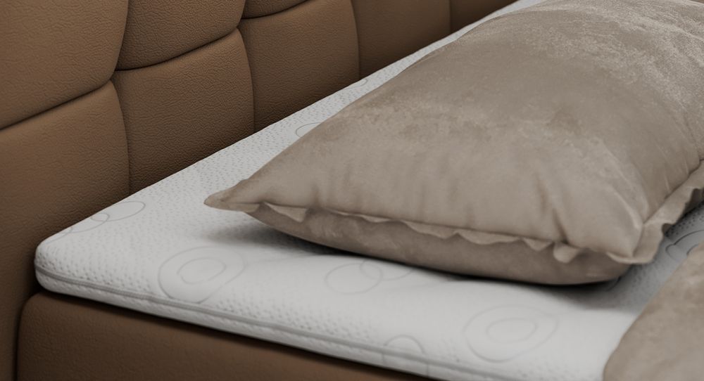 Gestepptes Kopfteil eines braun Bettes. Eine Topper-Matratze liegt auf dem Bett