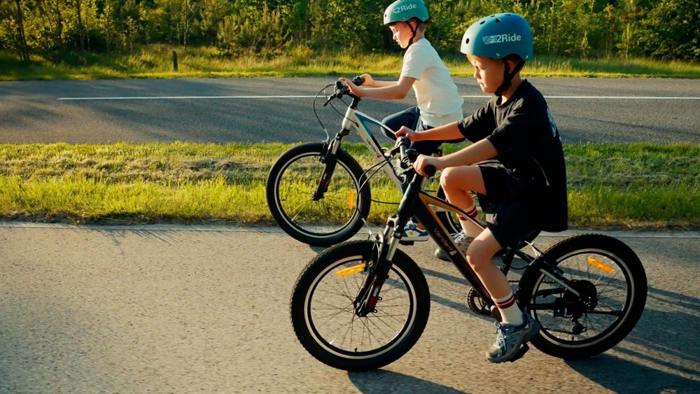 Niños montando la bicicleta Verdant Juniper al aire libre