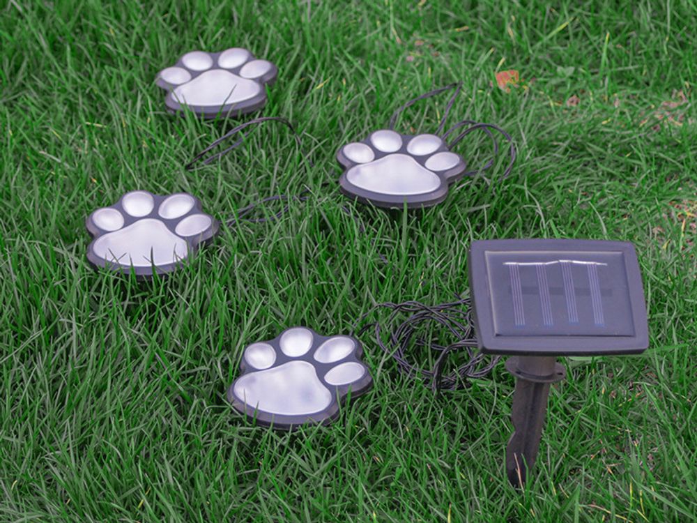 Solarbetriebene LED-Gartenleuchten in Pfotenform, beleuchten Rasen. Solarpanel im Boden.