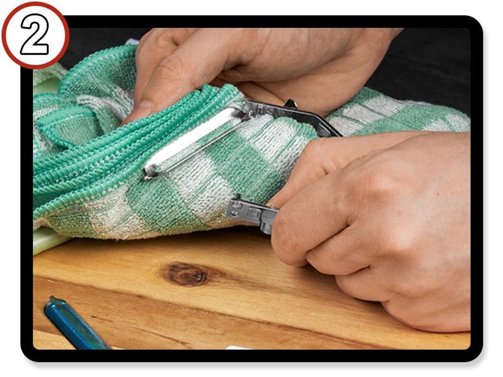 Daumen drückt den Bügel des TURBO Schälerkopfs auseinander, um die Klinge zu lösen