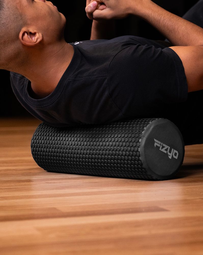 Trening Fitness z wałkiem do masażu z wypustkami 45x15 cm FIZYO — osoba wykonuje ćwiczenia