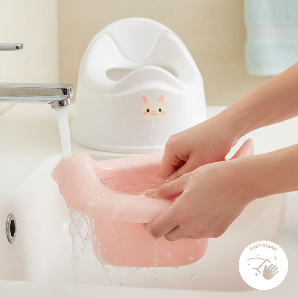 Recipiente del orinal SUN BABY siendo enjuagado en el lavabo
