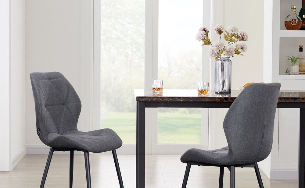 Das Bild zeigt einen Tisch mit zwei Stühlen und einer Vase.