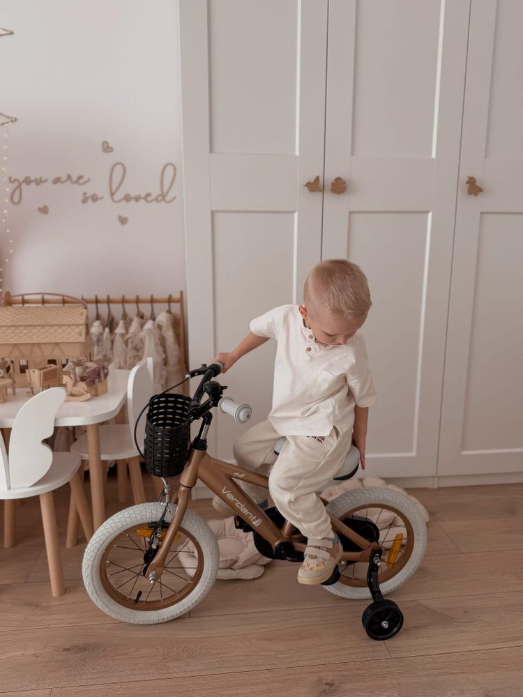 Kind fährt mit Stützrädern im Kinderzimmer