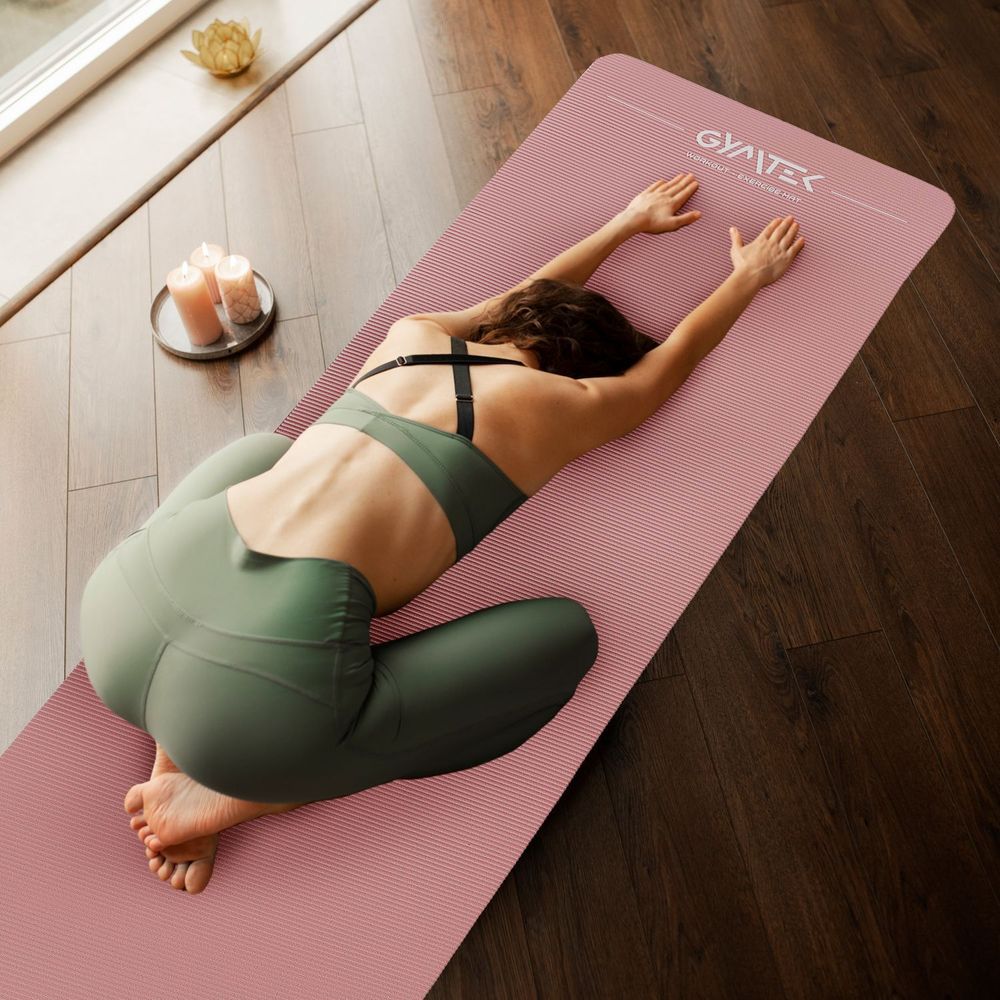 Frau macht Yoga-Übung auf rosa Gymnastikmatte zu Hause