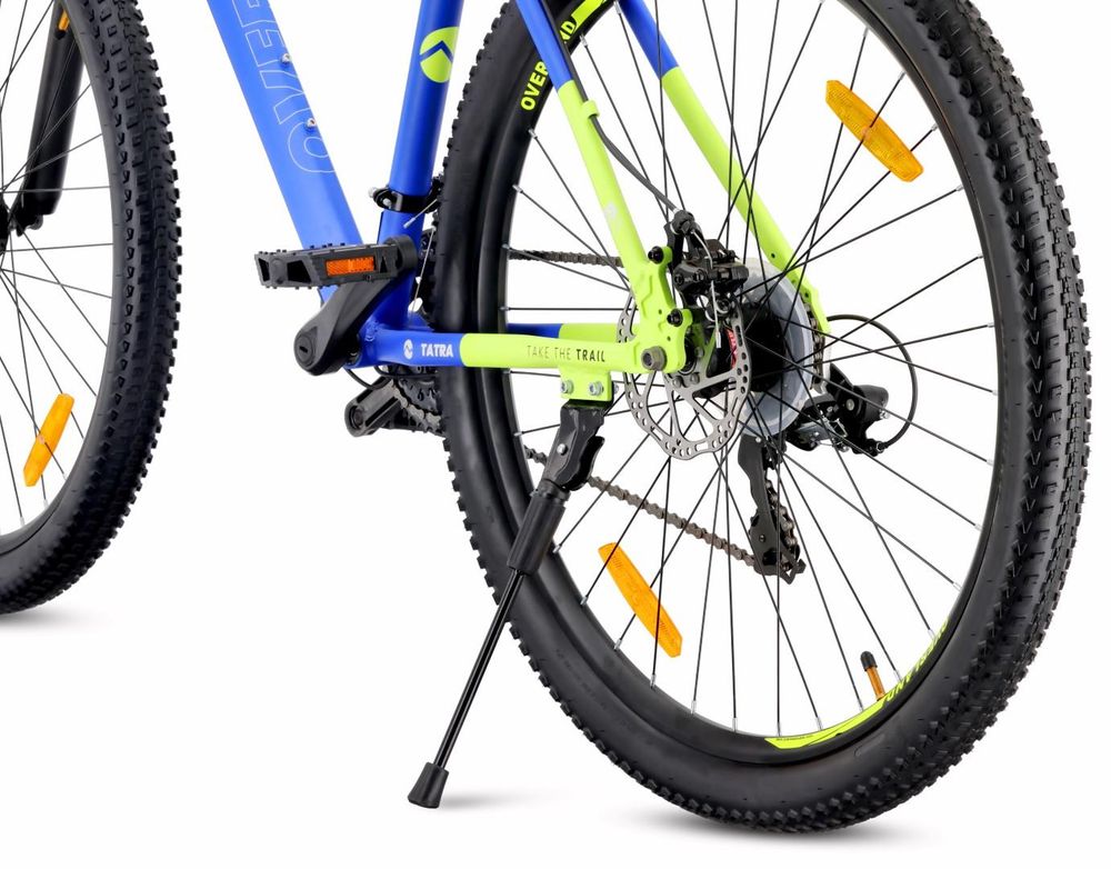Detalle de la rueda trasera, freno de disco y pata de apoyo de la bicicleta.