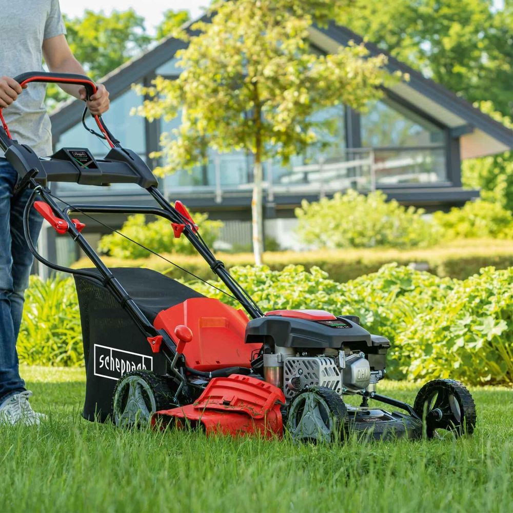 Das Bild zeigt den Rasenmäher bei der Arbeit im Garten.