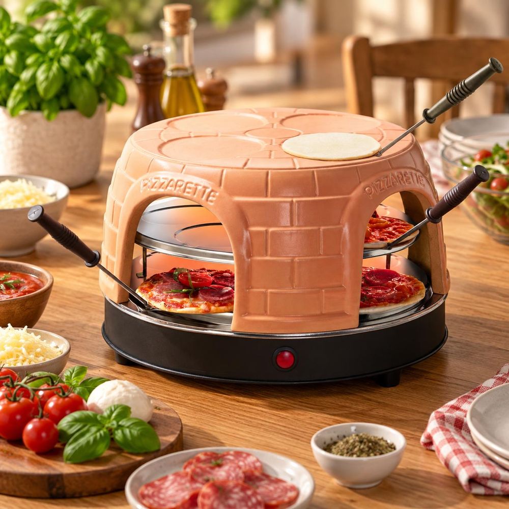 Pizzarette Pizzaofen mit Mini-Pizzen auf einem Holztisch, umgeben von frischen Zutaten.