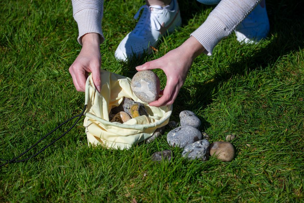 Das Bild zeigt, wie die Sandsäcke mit Steinen befüllt werden