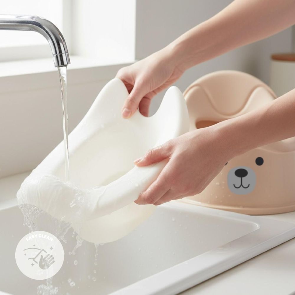 Insert amovible du pot bébé SUN BABY rincé sous un robinet.