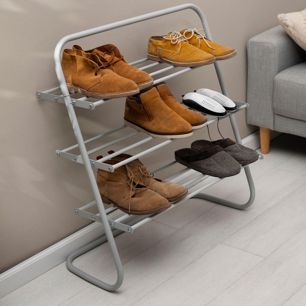 Graues Schuhregal mit mehreren Paar Schuhen und einem elektrischen Schuhtrockner