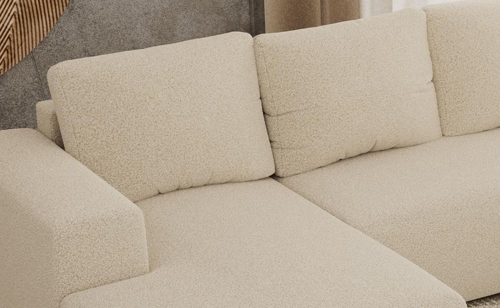 Detailansicht eines grauen Sofas mit breiten Sitzpolstern und weichen Rückenkissen.