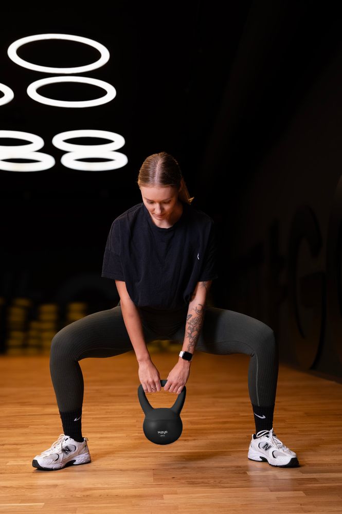 Osoba ćwiczy przy pomocy ciężarka hantla miękki kettlebell FIZYO
