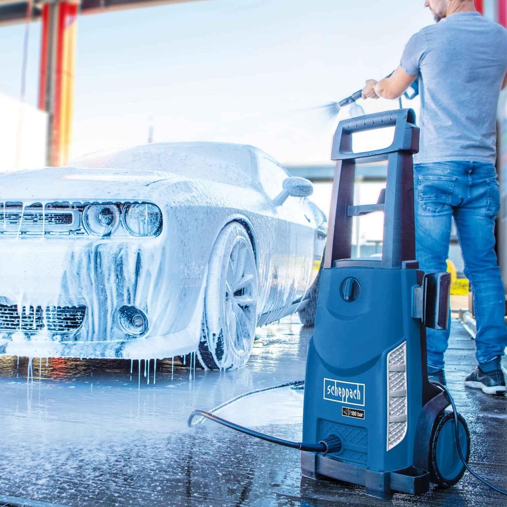Das Bild zeigt eine Person beim Autowaschen mit dem Hochdruckreiniger.