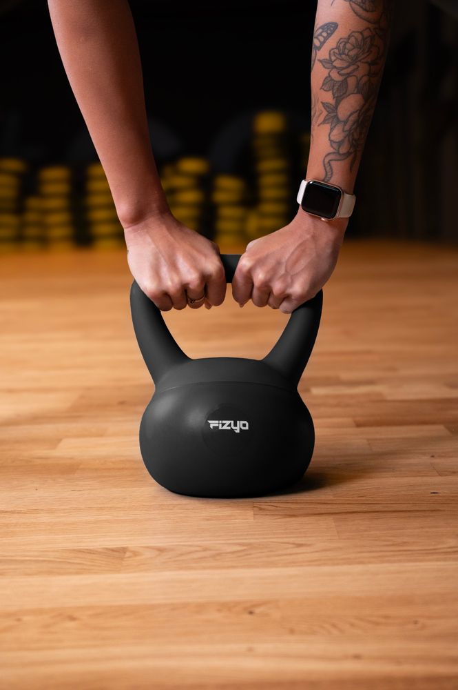 Osoba ćwiczy przy pomocy ciężarka hantla miękki kettlebell FIZYO