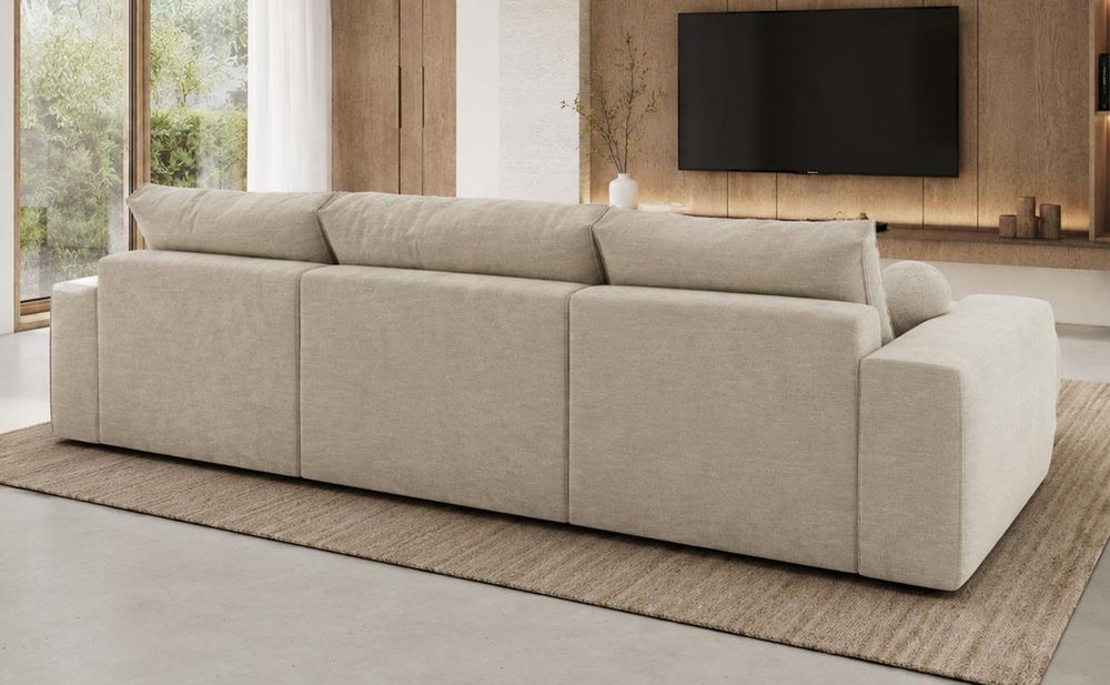 Beiges Ecksofa mit breiten Armlehnen in einem hellen Wohnzimmer.