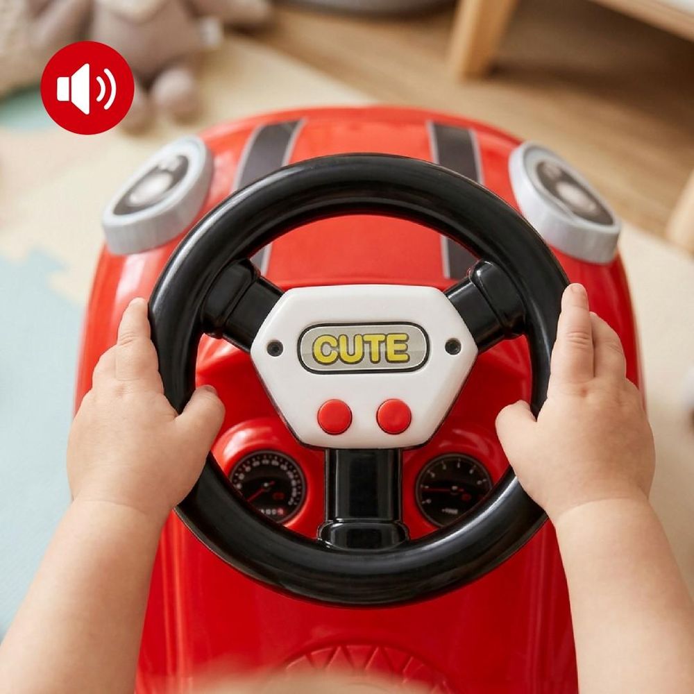 Gros plan sur les mains d'un enfant utilisant le volant interactif avec boutons sonores.