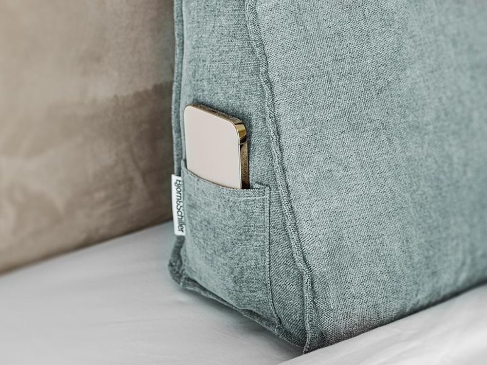 Smartphone in der seitlichen Tasche des Rückenkissens.