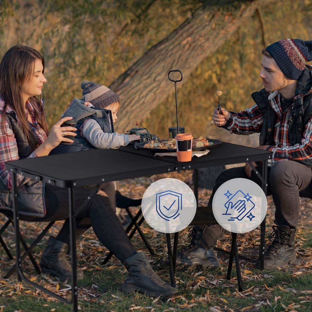 Familie beim Picknick am Camping-Tisch