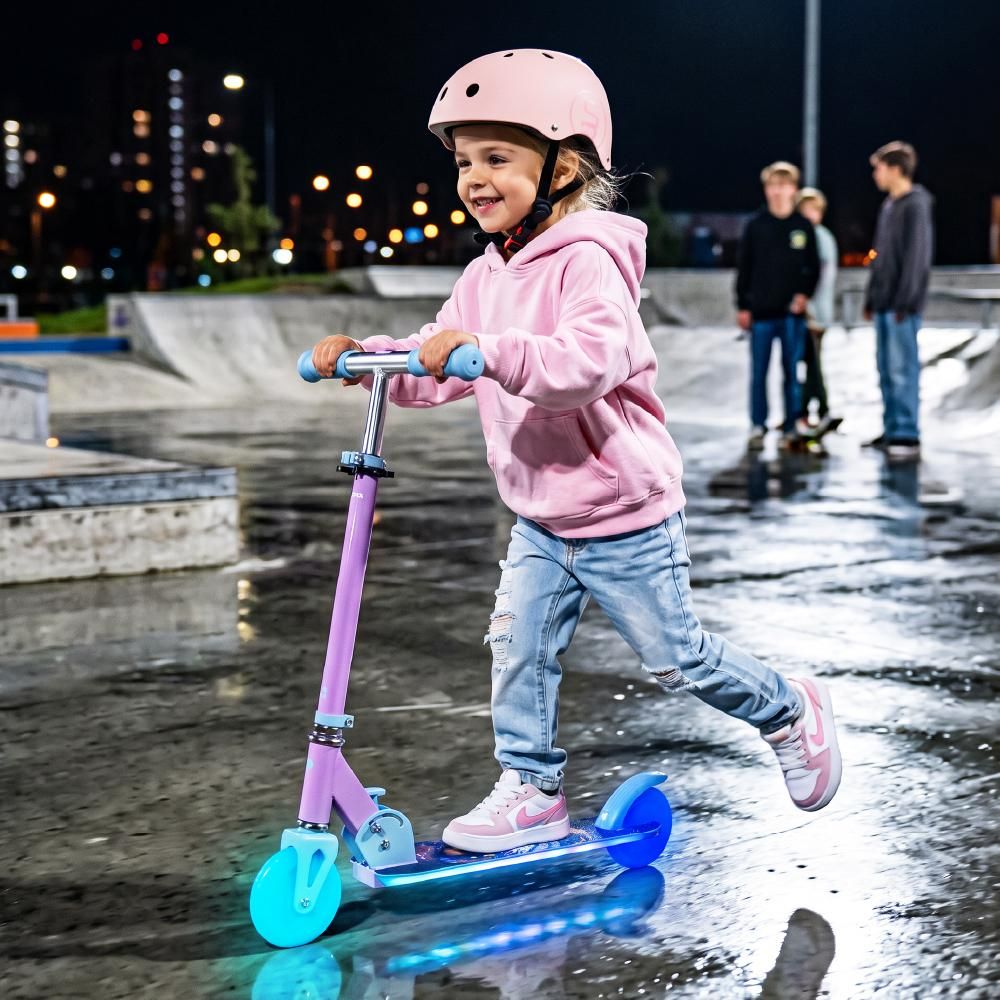 Kind rijdt op step met LED-verlichting in het donker