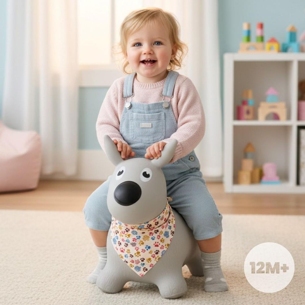 Enfant de 12 mois assis sur l'animal sauteur chien gris, souriant.