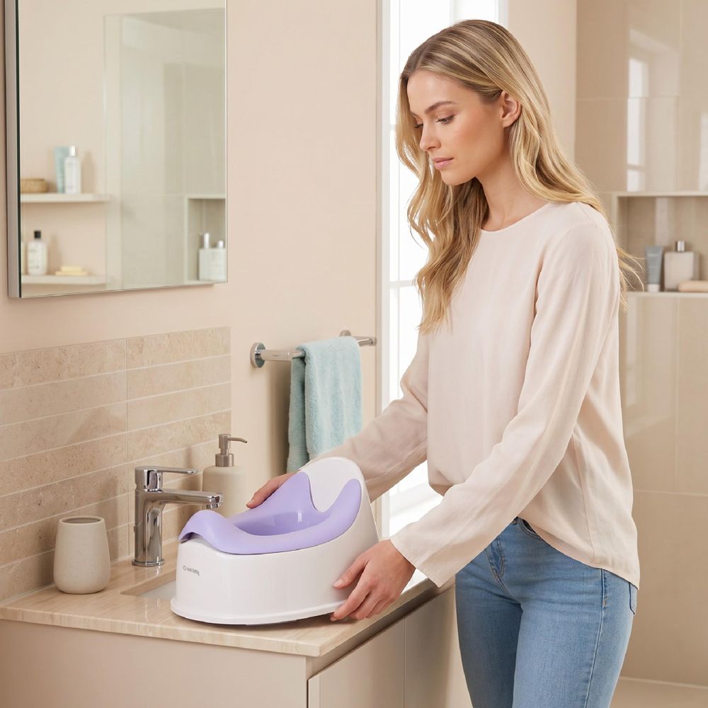 Adulte posant le pot bébé SUN BABY sur le sol de la salle de bain