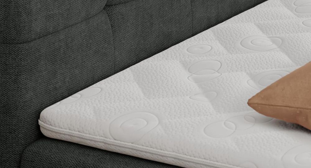 Gestepptes Kopfteil eines schwarz Bettes. Eine Topper-Matratze liegt auf dem Bett