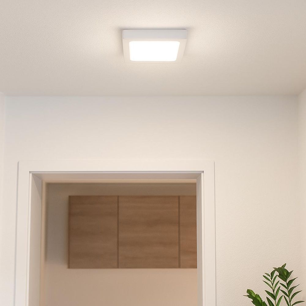 Quadratische LED-Deckenleuchte in Weiß, montiert in einem hellen Flur mit Pflanzenakzent.