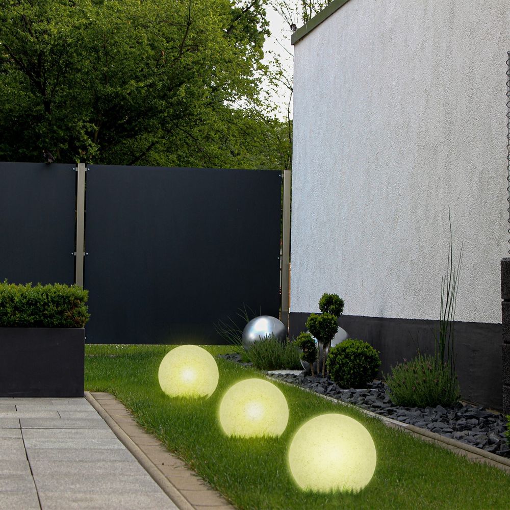 Gartenbeleuchtung, einfache Installation, weiße Solarkugeln entlang eines Beets.