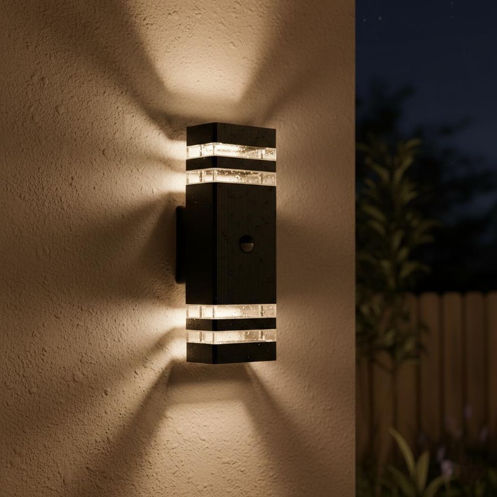 Schwarze Wandlampe, modernes Up-Down-Design, an weißer Wand mit Efeu.