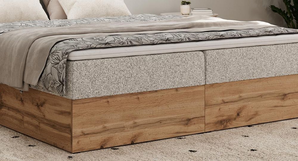 Braunes Bett mit Kunstlederbezug. Obere Matratze liegt auf dem Bett