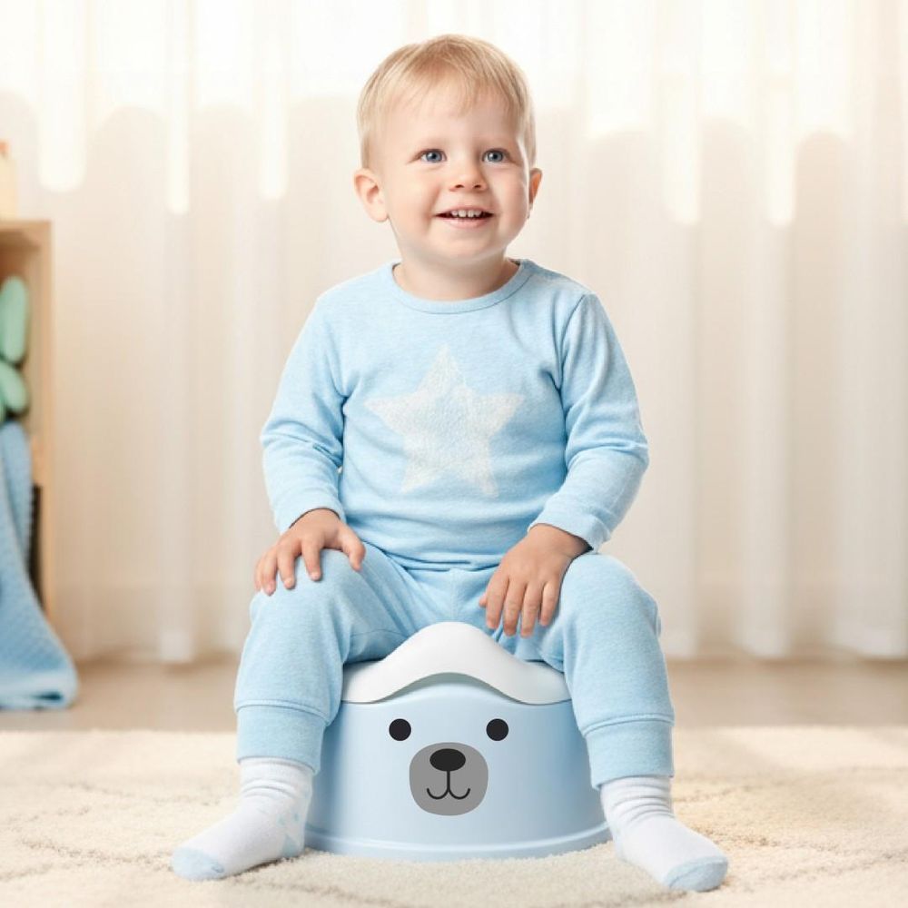 Niño sentado cómodamente en el orinal SUN BABY azul y blanco.