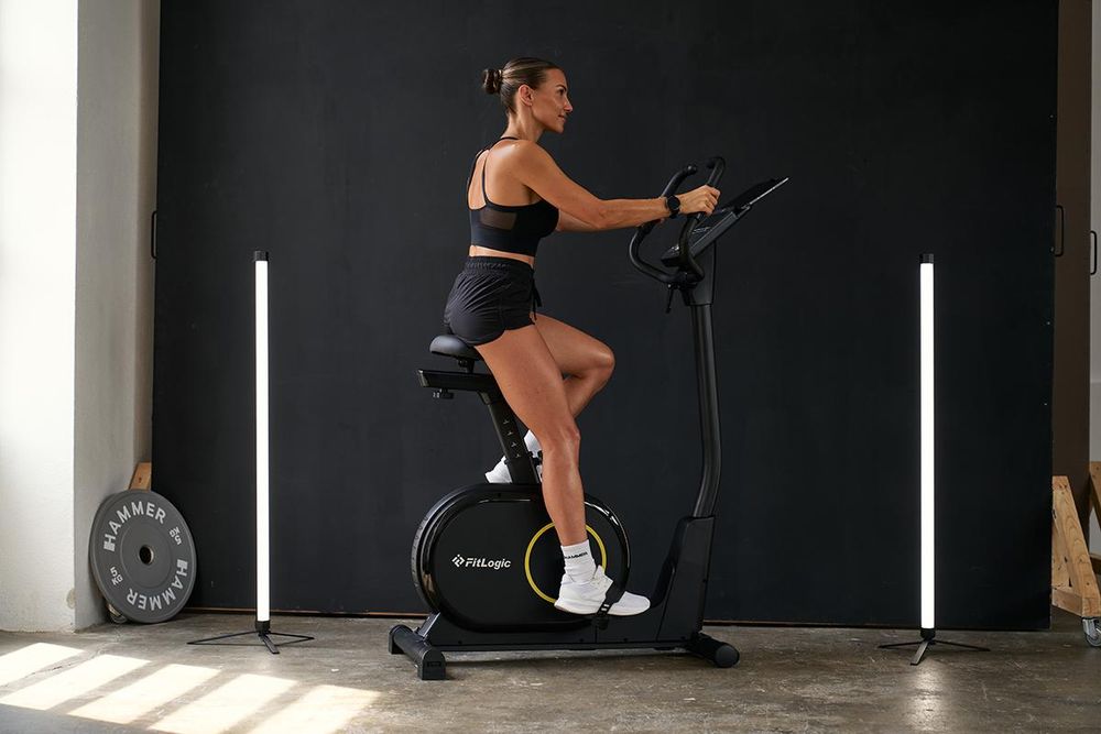 Das Bild zeigt eine Frau auf einem Ergometer, die gerade ein motivierendes Training absolviert.