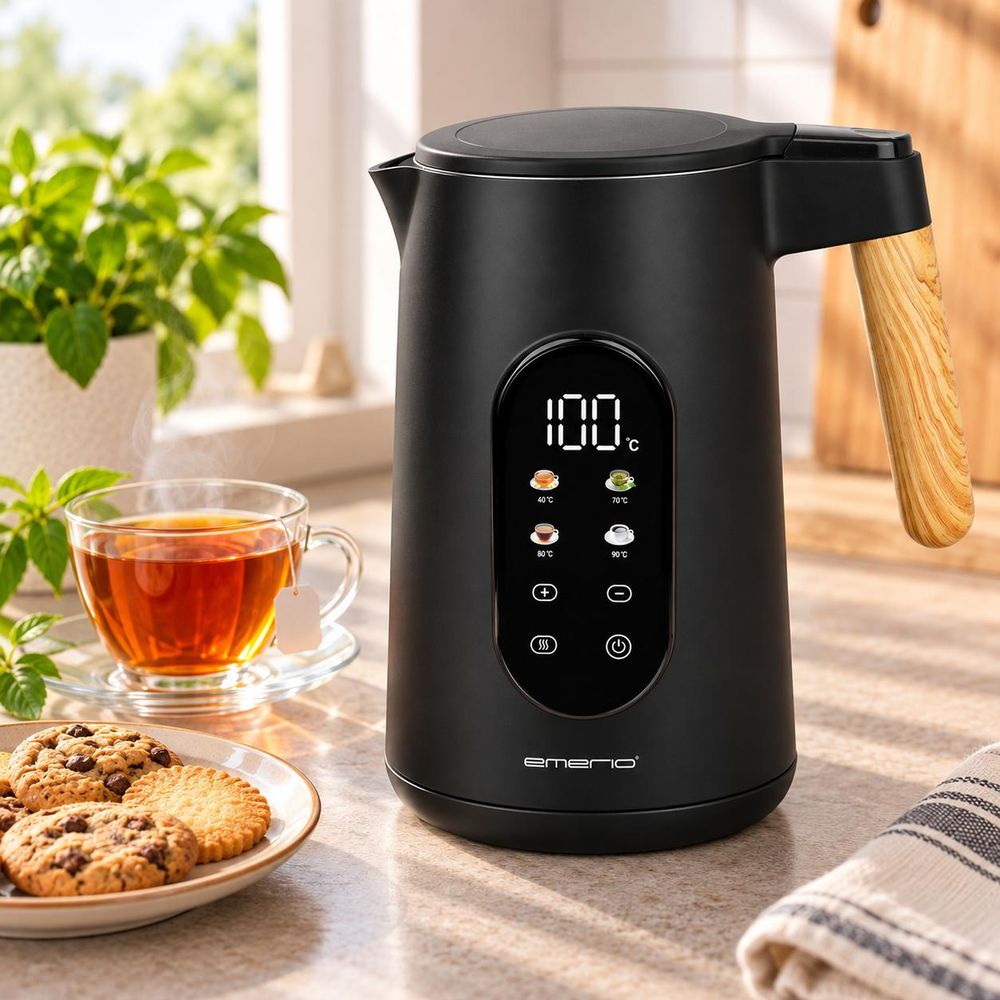 Schwarzer Emerio Wasserkocher mit Touchdisplay neben einer Tasse Tee und Keksen.