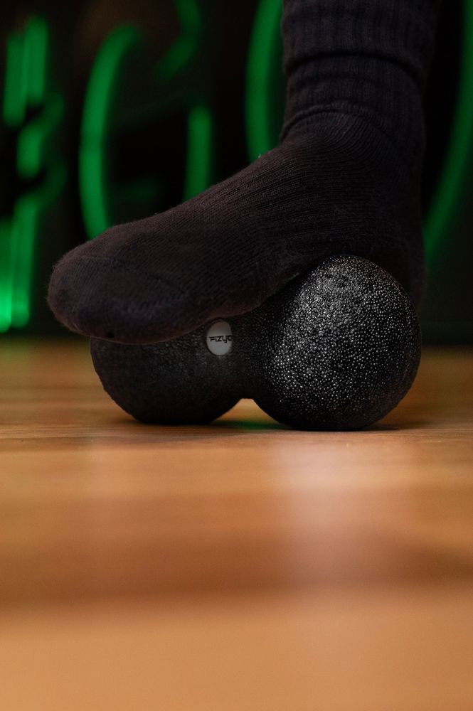 Person trainiert mit dem Massageball DuoBall FIZYO 16x8 cm