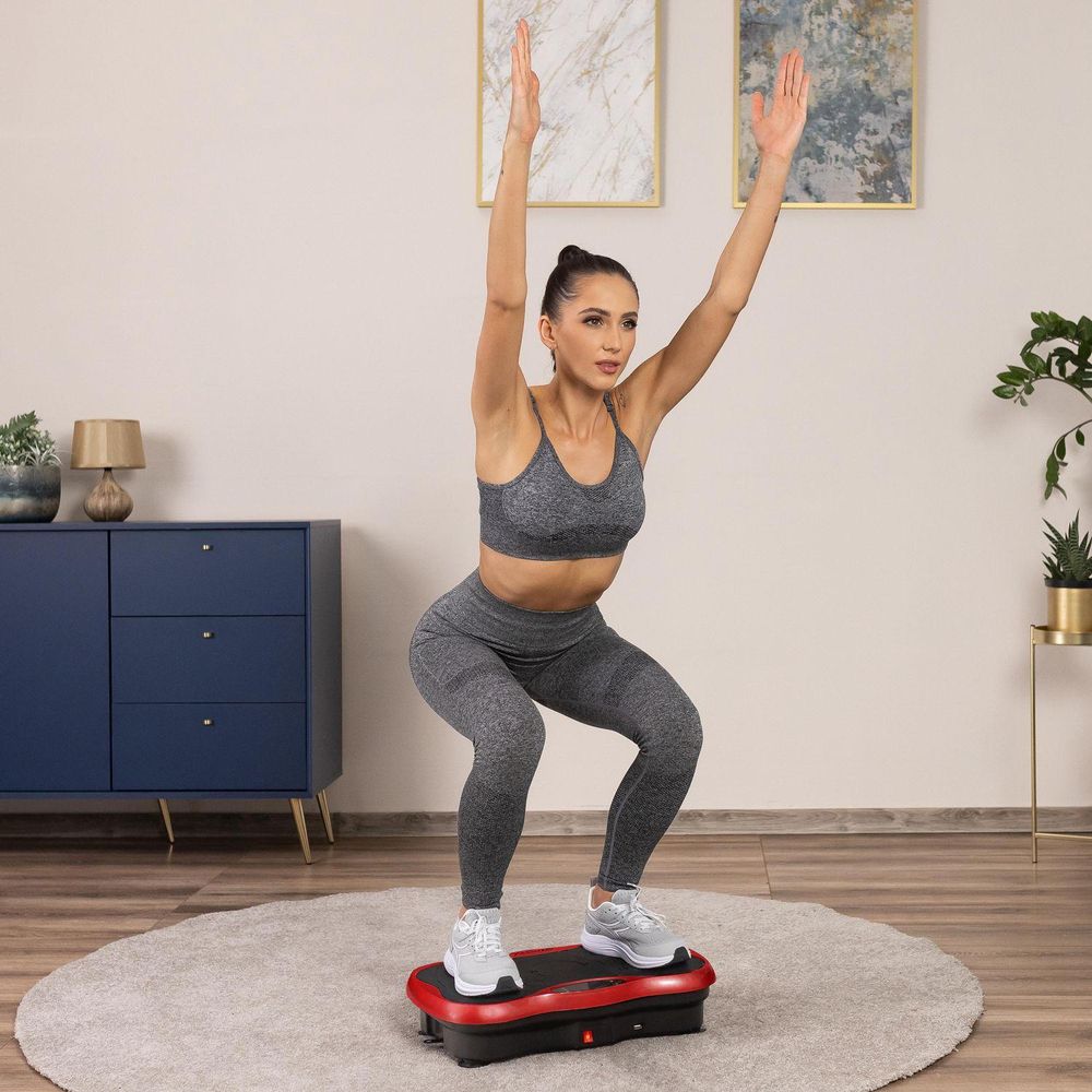 Frau macht Kniebeugen auf Vibrationsplatte für Ganzkörpertraining