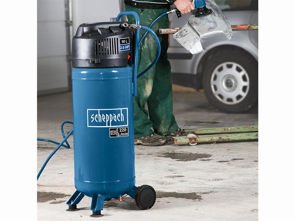 Das Bild zeigt einen Mann mit einer druckluftbetriebenen Maschine, die mit dem Kompressor läuft.