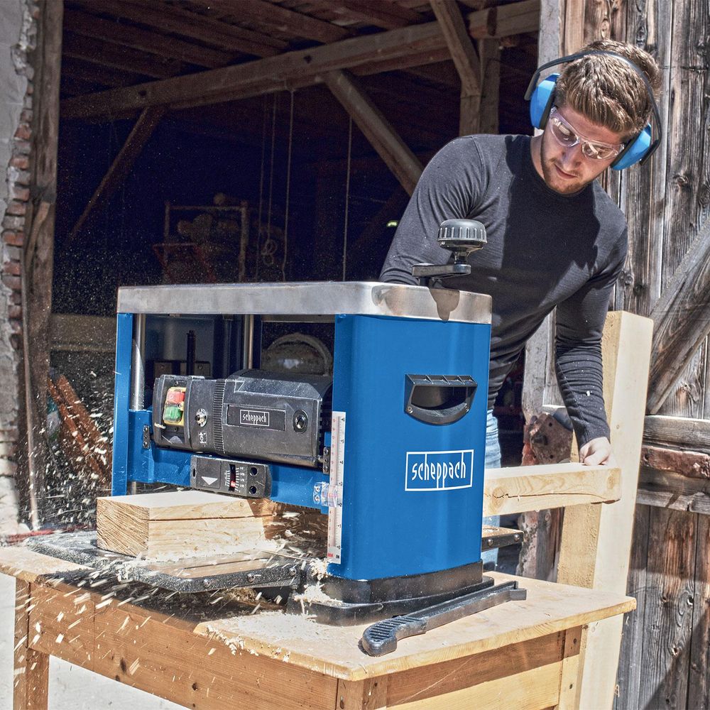 Das Bild zeigt eine Person bei der Arbeit mit Holz an der Maschine.