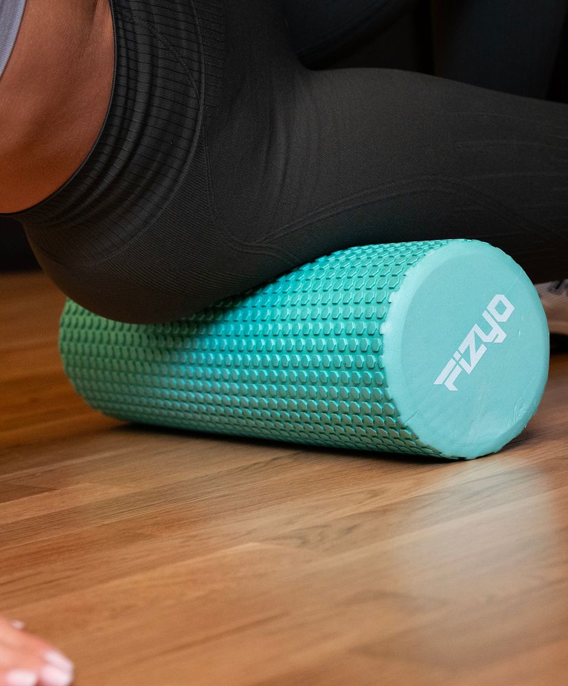 Trening Fitness z wałkiem do masażu z wypustkami 30x15 cm FIZYO — osoba wykonuje ćwiczenia
