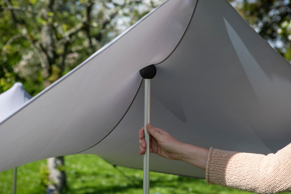 Das Bild zeigt eine Aluminiumstange und wie der Stoff über die Stange gespannt wird