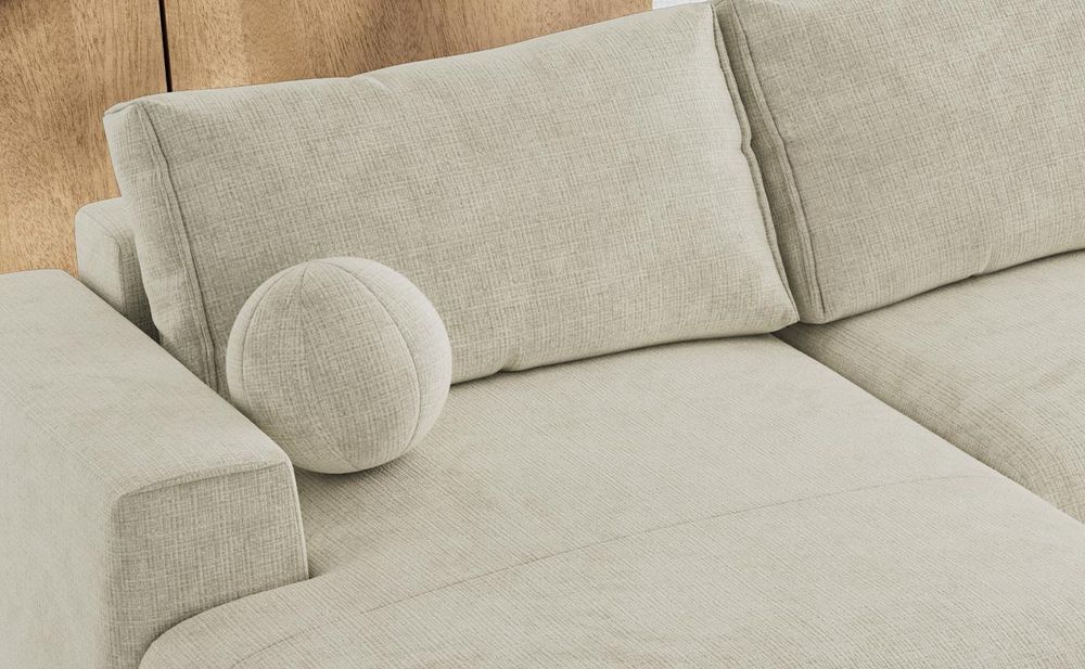 Detailansicht eines beigen Sofas mit breiten Sitzpolstern und weichen Rückenkissen.