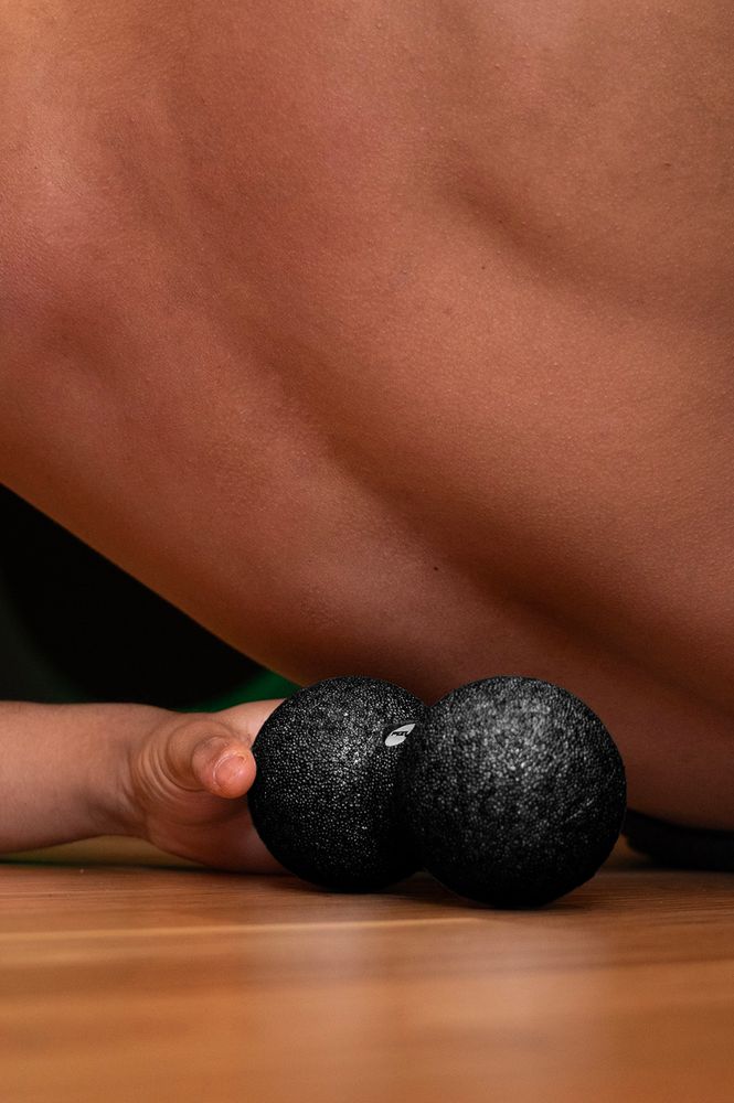 Person trainiert mit dem Massageball DuoBall FIZYO 16x8 cm